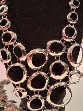This is a Lia Sophia bib necklace a bold design with interlocking silver Rounds